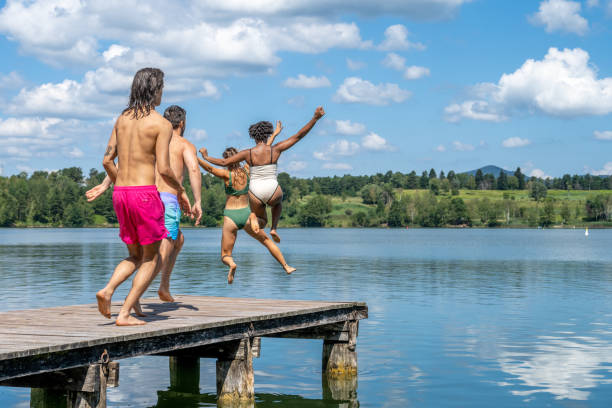 istock Friends jumping into lake 1455850007