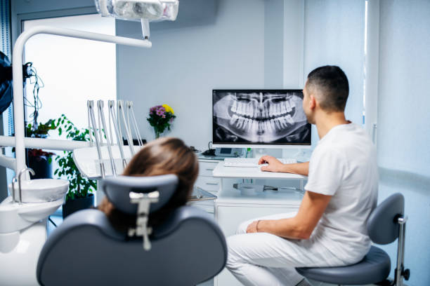 istock Dentist showing his patient the X-Ray oh her teeth. 1455851898