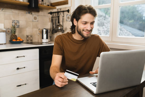 istock Young man making an online payment from home 1455853079