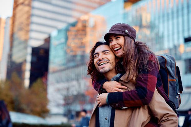 istock Cheerful couple having fun while piggybacking in the city. 1455853379