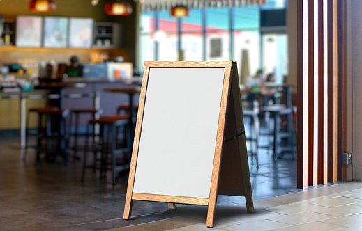Whiteboard signage stand in front of restaurant