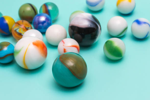 Toy marbles on an aqua colored background stock photo