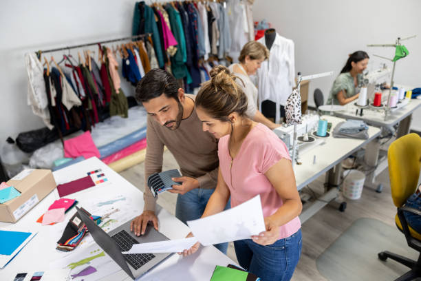 fashion designers working together at a clothing atelier - factory garment sewing textile imagens e fotografias de stock