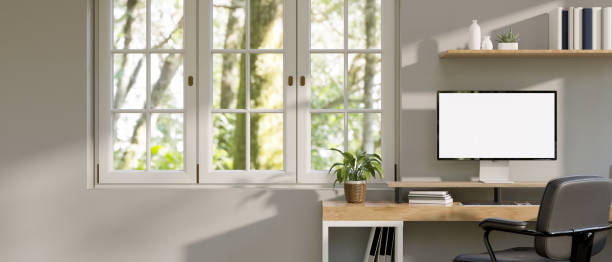 istock Minimal white home office with computer mockup on wood table, window with nature view 1455878190
