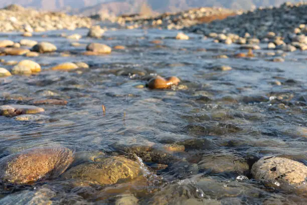 Photo of Mountain river shallow water stream on a sunny day