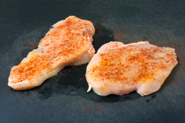 istock Boneless raw chicken breasts with paprika spice on cutting board 1455883355