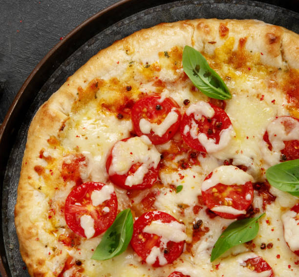 Freshly baked pizza on dark background.
