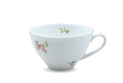 Empty white ceramic mug. Decorative flower pattern with one handle cup isolated on white background. Modern mug tea, coffee, or milk. Shiny bright color glazed vintage handmade for drinking water