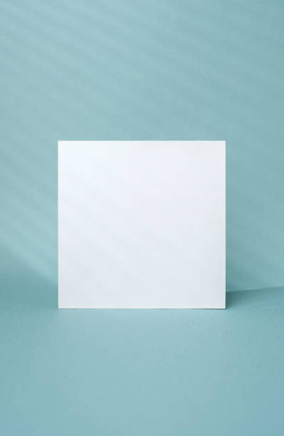 istock blank poster paper and window sunlight on pastel blue background 1455892180