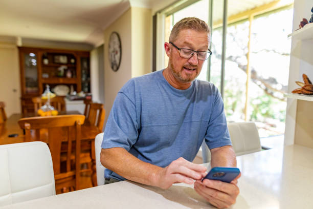 istock Mature Man Using a Smart Phone in the Kitchen 1455897024