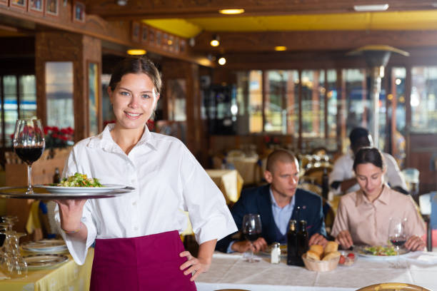 istock Professional attractive female waiter holding serving tray 1455901227