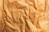 Rumpled brown cardboard paper texture background with copy space