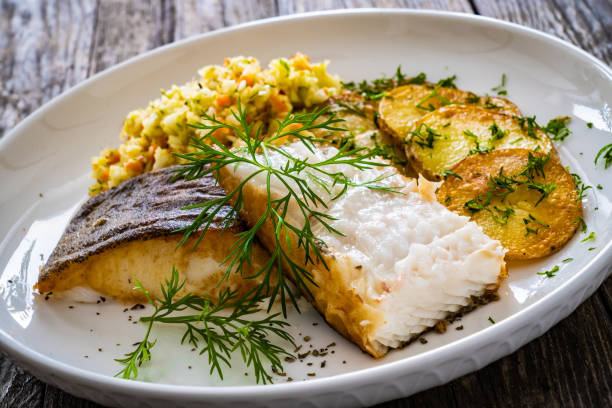 istock Fried halibut and potatoes with cabbage salad on wooden table 1455902155