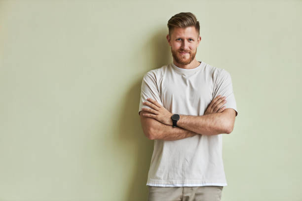istock Minimal bearded young man smiling at camera standing with arms crossed 1455902486