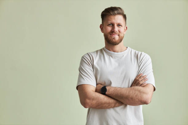 istock Bearded young man smiling at camera standing with arms crossed 1455902507