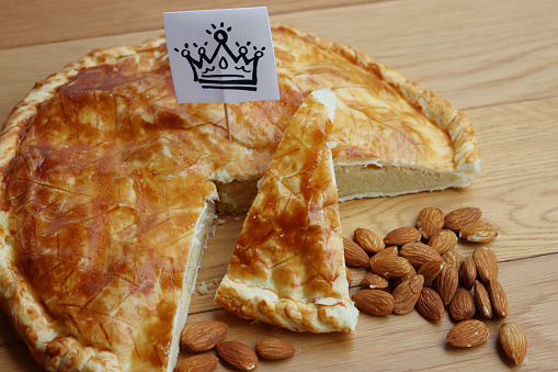 Galette des rois, traditional french cake with almond cream on wooden table. Epiphany cake