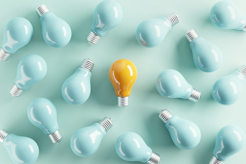 Minimal idea of yellow light bulb surrounded with blue bulbs on pastel background. 3d rendering. Idea creative Concept. Copy space.