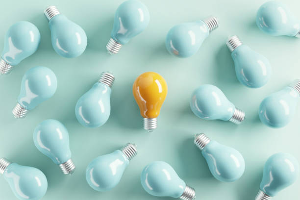 Minimal idea of yellow light bulb surrounded with blue bulbs on pastel background. 3d rendering. Idea creative Concept. Copy space. Minimal idea of yellow light bulb surrounded with blue bulbs on pastel background. 3d rendering. Idea creative Concept. Copy space. variegated stock pictures, royalty-free photos & images