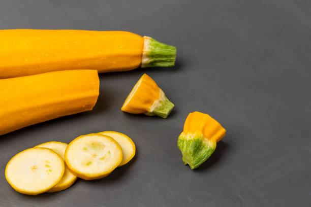 Chopped zucchini and whole zucchini. Copy space. Top view. Gray background.