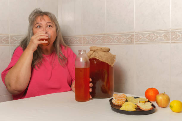 発酵昆布茶を飲む女性 - fungus science bottle glass ストックフォトと画像