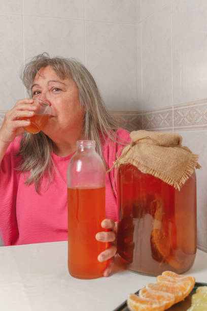 発酵昆布茶を飲む女性 - fungus science bottle glass ストックフォトと画像