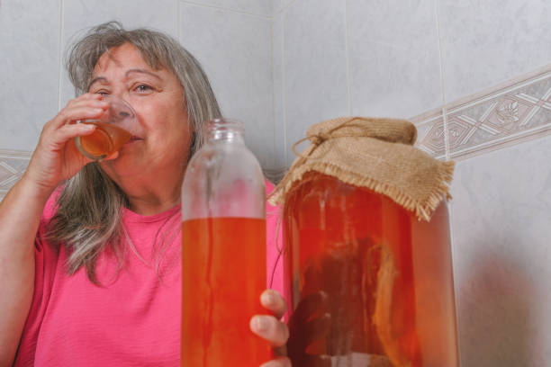 発酵昆布茶を飲む女性 - fungus science bottle glass ストックフォトと画像