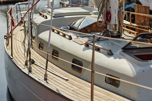 Close up of sailing yacht in sunlight with focus on wooden floors, copy space