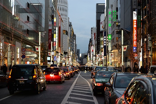 Tokyo, Japan – January 03, 2020: A beautiful shot of Ginza cars and buildings with neon signs in Tokyo, Japan