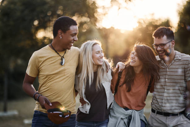 istock Cheerful friends talking while walking embraced in nature. 1455916084