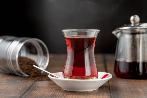 Freshly brewed turkish tea in thin-waisted glass cup on wooden table stock photo