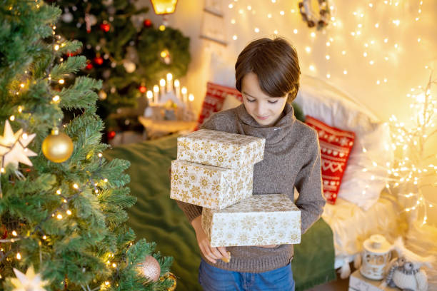 istock Cute child, boy, playing in decorated room for Christmas, decorating tree 1455925716