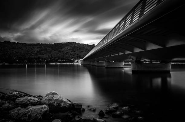 istock Grayscale of a bridge above the water 1455928005