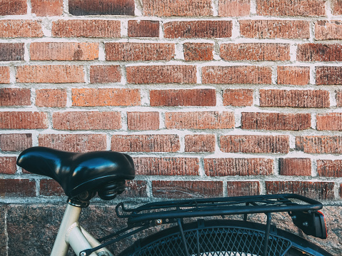 Bicycle seat leaning on to brick wall in Halmstad, Sweden