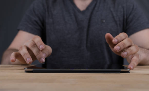 istock Closeup of a man typing on a tablet 1455929911