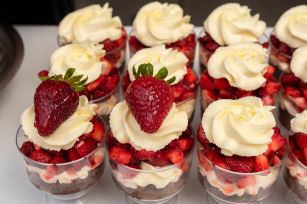 istock Process of making chocolate desserts in cups with chocolate, biscuit, cream, and strawberries 1455932500