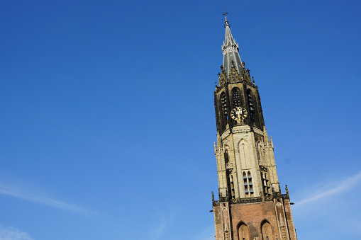 Delft, Netherlands – March 26, 2012: The Nieuwe Kerk distinguishable Protestant church with clock tower in the city square.