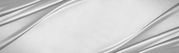 istock White light gray silk satin. Draped fabric. Silver color. Luxury background with space for design.  Flat lay, top view table. 1455935214