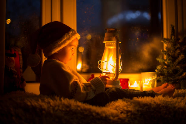 istock Cute child, sitting on a window, looking outdoors for Santa Claus 1455937866