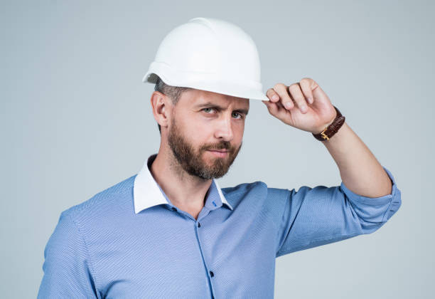 istock handsome smiling bearded businessman in helmet, business engineer 1455939972
