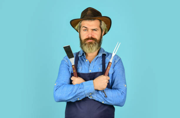 istock Bbq american tradition. Culinary concept. Medium rare. Bbq food. Tools roasting meat. Man in apron hold barbecue grill. Farmer promoting bbq equipment. Cooking steak. Cooking utensils. Summer picnic 1455940350