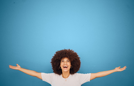 Winner, mockup and excitement with a black woman in celebration in studio on a blue background for marketing or advertising. Motivation, space and product placement with a female cheering in victory