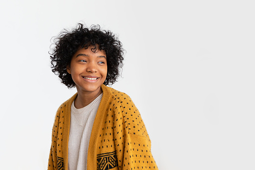 Beautiful african american girl with afro hairstyle smiling isolated on white background with copy space. Young african woman with curly hair laughing. Freedom happiness carefree happy people concept