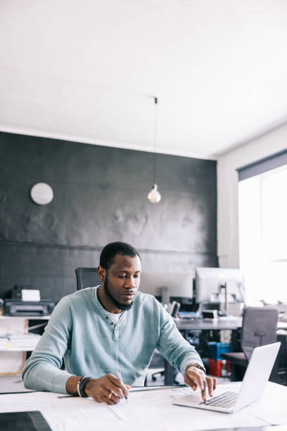 istock The architect works on the blueprint, using the laptop to access 3D modeling software and create detailed visualizations of the building. 1455943811