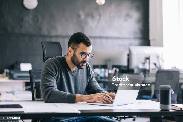 The Architect Takes Notes On The Blueprint Then Inputs Them Into The Laptop To Keep An Digital Record Of The Design Process Stock Photo - Download Image Now