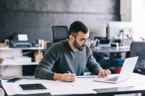 istock The architect uses the laptop to research different materials and technologies, incorporating them into the design of the building. 1455943829