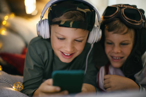 brothers playing game on their smart phone. - aviator glasses audio imagens e fotografias de stock