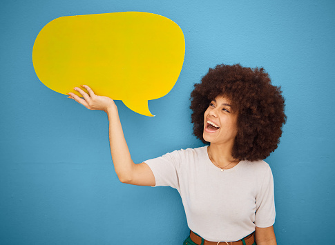 Black woman with yellow speech bubble, afro and blue background mockup space for advertising or product placement. Smile, announcement sign and woman excited for small business discount sale launch.