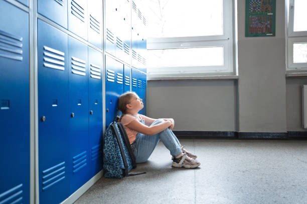 istock School girl sitting in the school corridor 1455946416