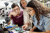 College instructor assisting electrical engineering students