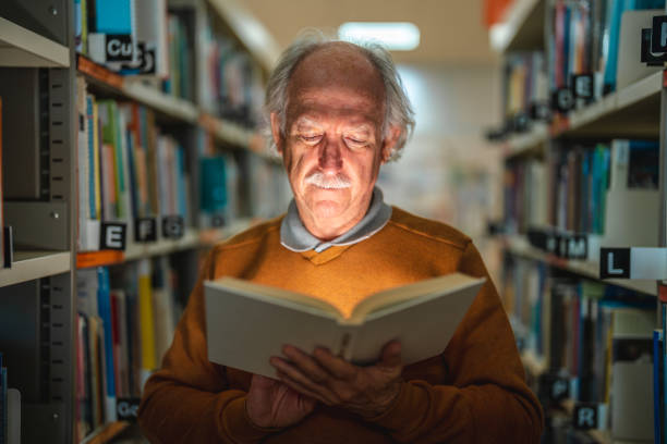 istock Senior Male Standing Between Bookshelves In A Library 1455947866